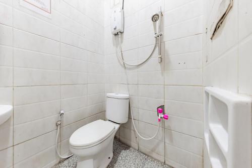 a bathroom with a toilet and a shower at RedDoorz near Kejaksan Station Cirebon in Cirebon