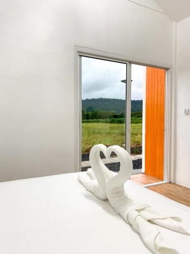 a white bedroom with a bed with a window at DOO KHAO in Ban Chong Tako