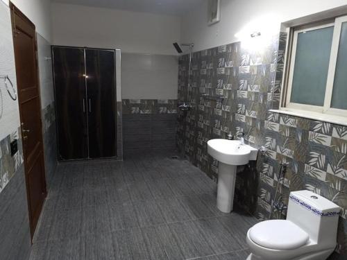 a bathroom with a toilet and a sink and a shower at Pace view Hotel Gulberg,Lahore in Lahore