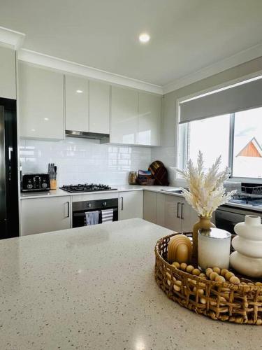 a kitchen with a counter top with a basket of dishes at Hillston House in Kiama