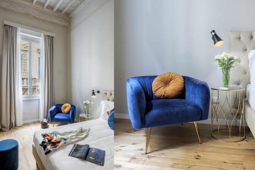 a living room with a blue chair and a couch at Dimora72 Luxury Rooms in Florence
