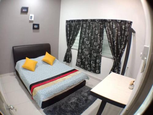 a bedroom with a bed with yellow pillows and a mirror at AVENUE HOMESTAY 5 Room 4 Toilet 4 MINUTES TO TOWER in Teluk Intan