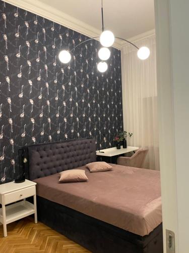 a bedroom with a large bed and a black wall at Nightingale apartment in Liepāja