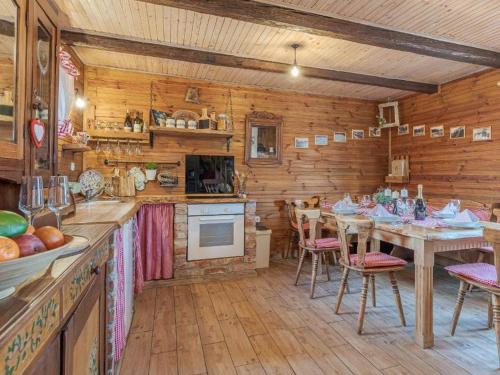 una cucina con tavolo e sedie in una cabina di Stara hiža Vlašić a Kostanjevac
