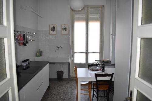 a kitchen with a table and a sink and a dining room at La Mascarella in Alba