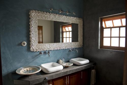 a bathroom with two sinks and a mirror at Cultivar Boutique Hotel in Stellenbosch
