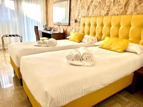 duas camas num quarto de hotel com toalhas em RobHouse em Passo Corese