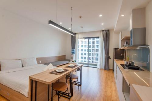 a hotel room with a bed and a table and a kitchen at Cozy Vinhomes D Capital 1 in Hanoi
