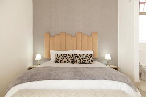 a bedroom with a large bed with two lamps at The City Club in Cape Town