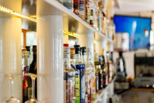 a row of bottles of alcohol on a shelf in a store at Hotel Matheo Villas & Suites in Malia