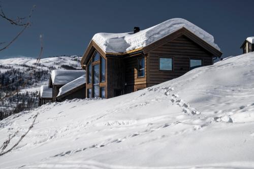 a house on a hill covered in snow at The Panorama Retreat - Rindabotn Cabin in Sogndal