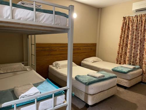 a bedroom with three bunk beds and a couch at Baron Water Front in Kuah