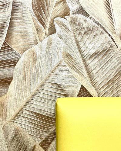 a wall with a leafy wallpaper with a yellow object at RobHouse in Passo Corese
