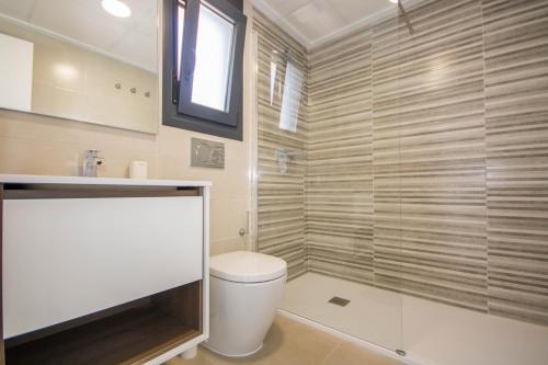 a bathroom with a toilet and a glass shower at Villa BALI 3032 in Vistabella
