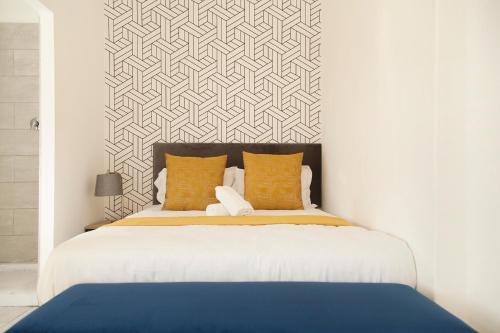 a bedroom with a large bed with orange pillows at The City Club in Cape Town