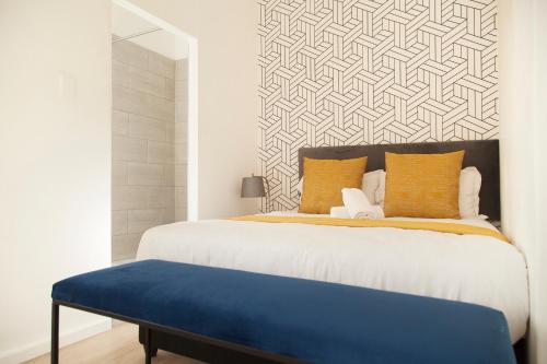 a bedroom with a large bed with a blue bench at The City Club in Cape Town