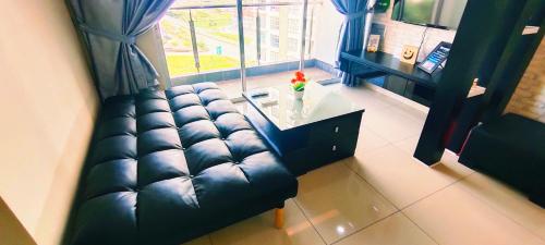 a living room with a couch and a table and a window at Kulai d putra suites beside ioiMall near JPO and Airport in Kulai