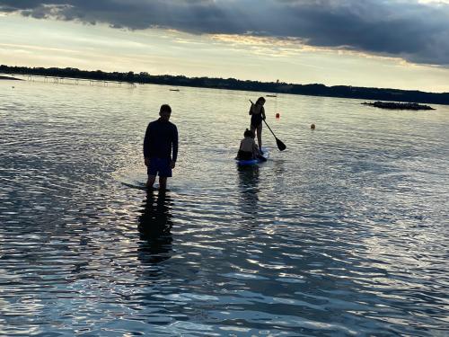 a group of people standing in a body of water at Strandhuset. in Asperup