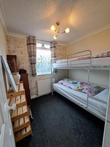 1 dormitorio con 2 literas y ventana en Beach & Tonic beachside chalet, en Humberston