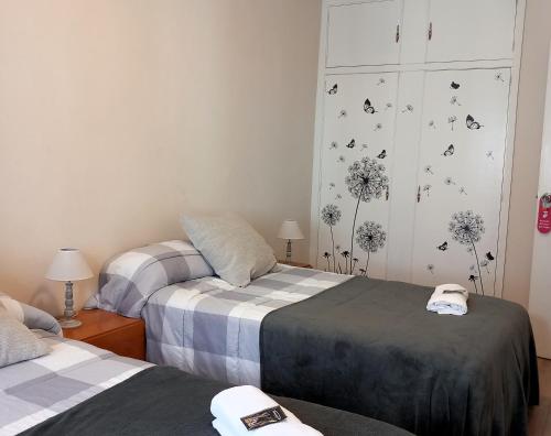 a bedroom with two beds and a wall with butterflies at Pensión Fornos in Caldas de Reis
