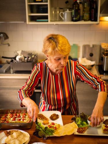 a woman standing in a kitchen preparing food at COMME A LA MAISON in Espéraza