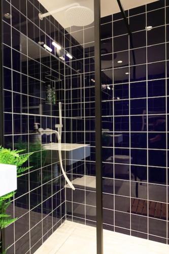 a black tiled bathroom with a shower and a sink at Wolverdene - Entire ground floor flat with garden in Margate