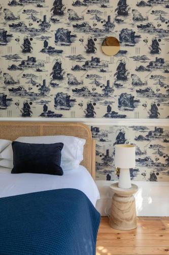 a bedroom with a bed and a wall with a wallpaper at Wolverdene - Entire ground floor flat with garden in Margate