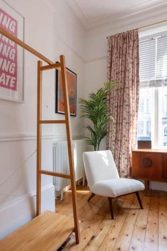 a living room with a ladder and a white chair at Wolverdene - Entire ground floor flat with garden in Margate