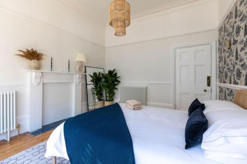 a bedroom with a large white bed with blue pillows at Wolverdene - Entire ground floor flat with garden in Margate