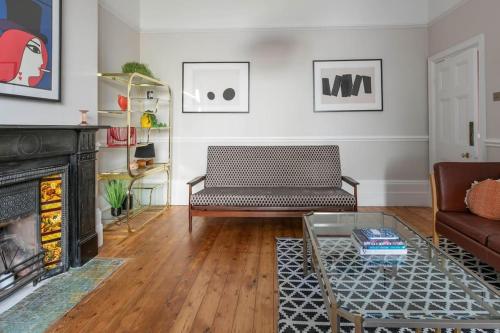 a living room with a couch and a fireplace at Wolverdene - Entire ground floor flat with garden in Margate