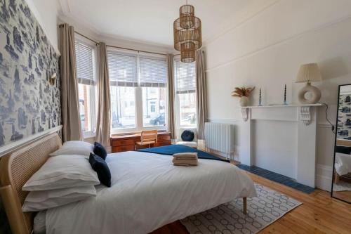 a bedroom with a large white bed and windows at Wolverdene - Entire ground floor flat with garden in Margate