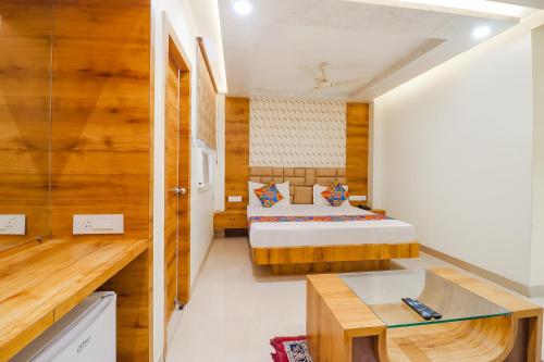 ein Schlafzimmer mit einem Bett und einem Schreibtisch in einem Zimmer in der Unterkunft FabHotel Holiday Grand in Patna