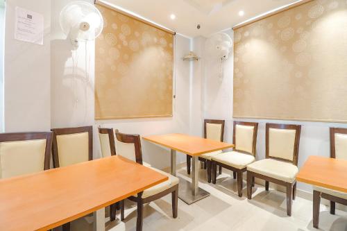 a dining room with wooden tables and chairs at FabHotel Holiday Grand in Patna
