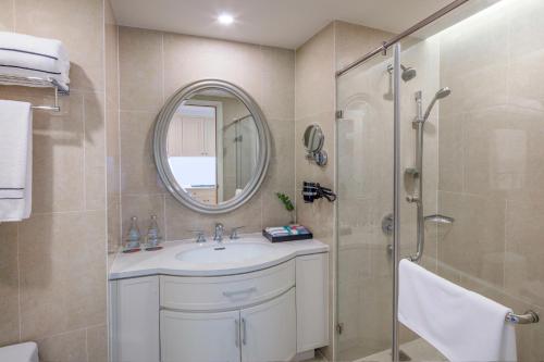 a bathroom with a sink and a shower with a mirror at Meliá Vinpearl Nha Trang Empire in Nha Trang
