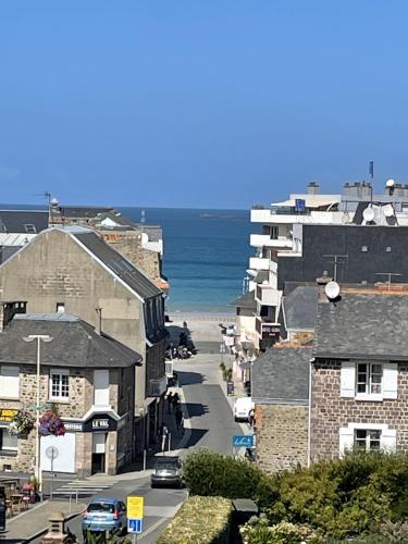 a city street with buildings and the ocean at Grand studio Clémenceau Vue mer 3 étoiles in Pléneuf-Val-André