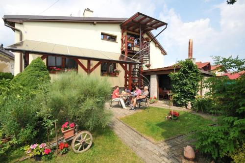 personas sentadas en el jardín de una casa en Penzión Mária, en Smižany