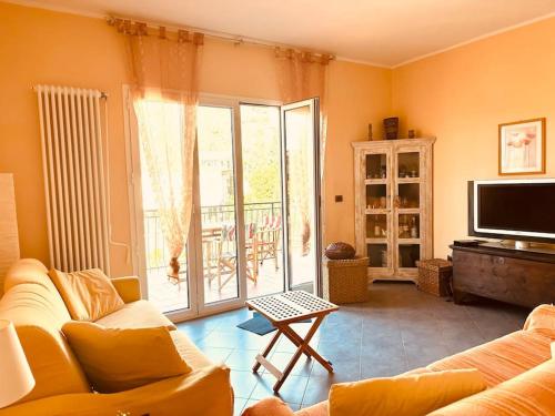 Una sala de estar con un sofá y un televisor. en Casa Delfina, en Tellaro