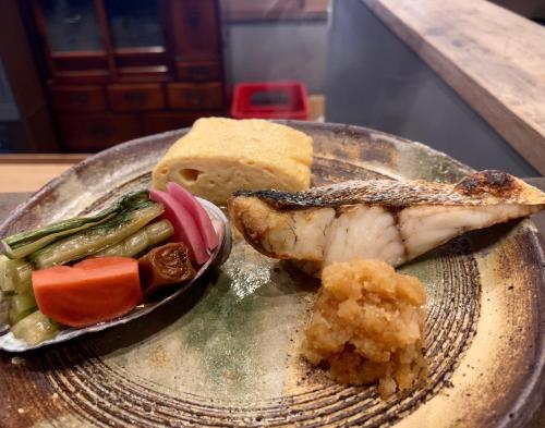 ein Teller mit Fisch und Gemüse darauf in der Unterkunft Mitsubikiya in Matsumoto