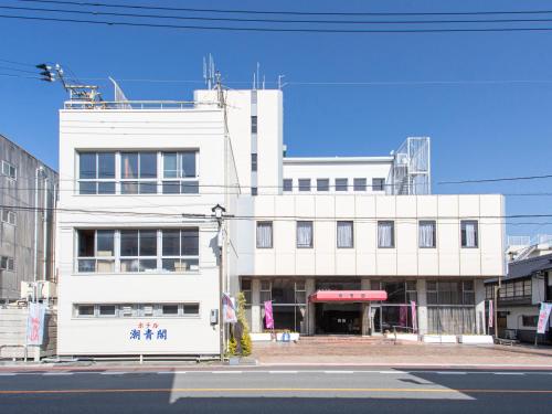 a large white building on a city street at Tabist Hotel Chouseikaku in Yatsushiro