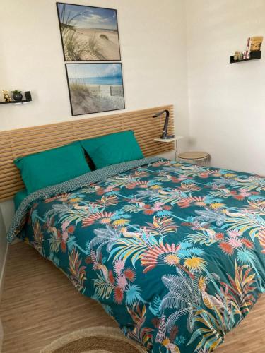 1 dormitorio con 1 cama con un edredón colorido en Sarzeau, st Jacques Vue pleine mer, possibilité nuitée en Sarzeau