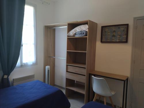 a bedroom with a bed and a desk and a chair at COMME A LA MAISON in Espéraza