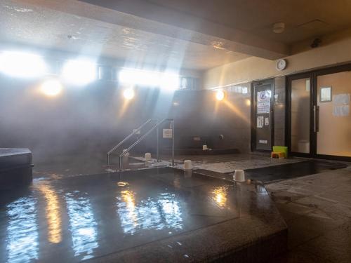 a room with a pool of water in a building at Tabist Hotel Chouseikaku in Yatsushiro