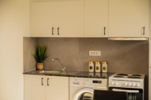 a kitchen with a sink and a washing machine at GK Home II part of GK FITNESS CLUB in Faliraki