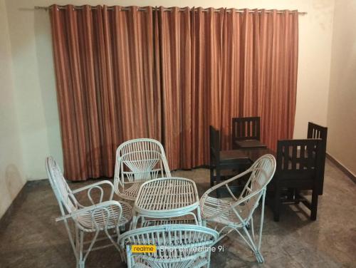 um quarto com cadeiras, uma mesa e uma cortina em Hotel Manglam Plaza By WB Inn em Sawai Madhopur