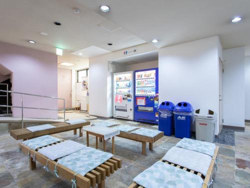 a waiting room with benches and trash cans at Tabist Hotel Chouseikaku in Yatsushiro
