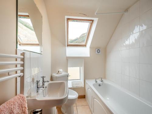 a bathroom with a sink and a tub and a toilet at Stonefield Farm Cottage in Benmore