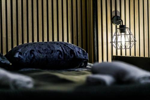 a pillow on a bed next to a lamp at Rzeźnicza 24 in Wrocław