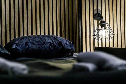 a bed with a blue pillow and a lamp at Rzeźnicza 24 in Wrocław