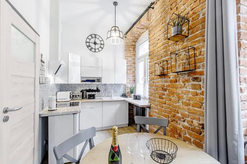 a kitchen with a table and a brick wall at Rzeźnicza 24 in Wrocław