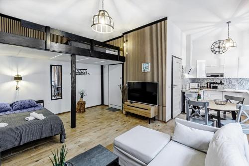 a living room with a bed and a kitchen at Rzeźnicza 24 in Wrocław